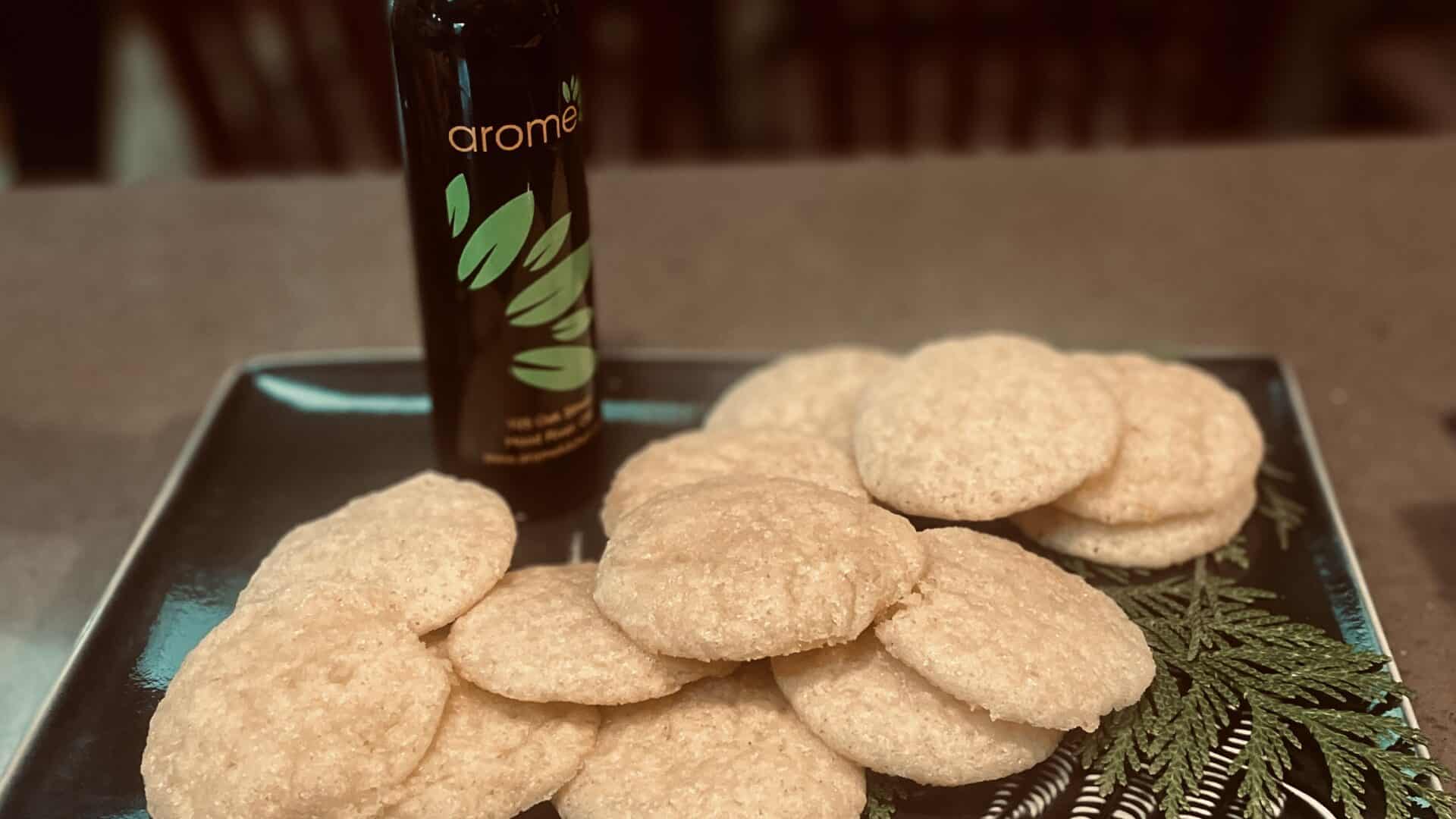 Lemon Olive Oil Cookies on a green plate with a bottle of Lemon fused olive oil